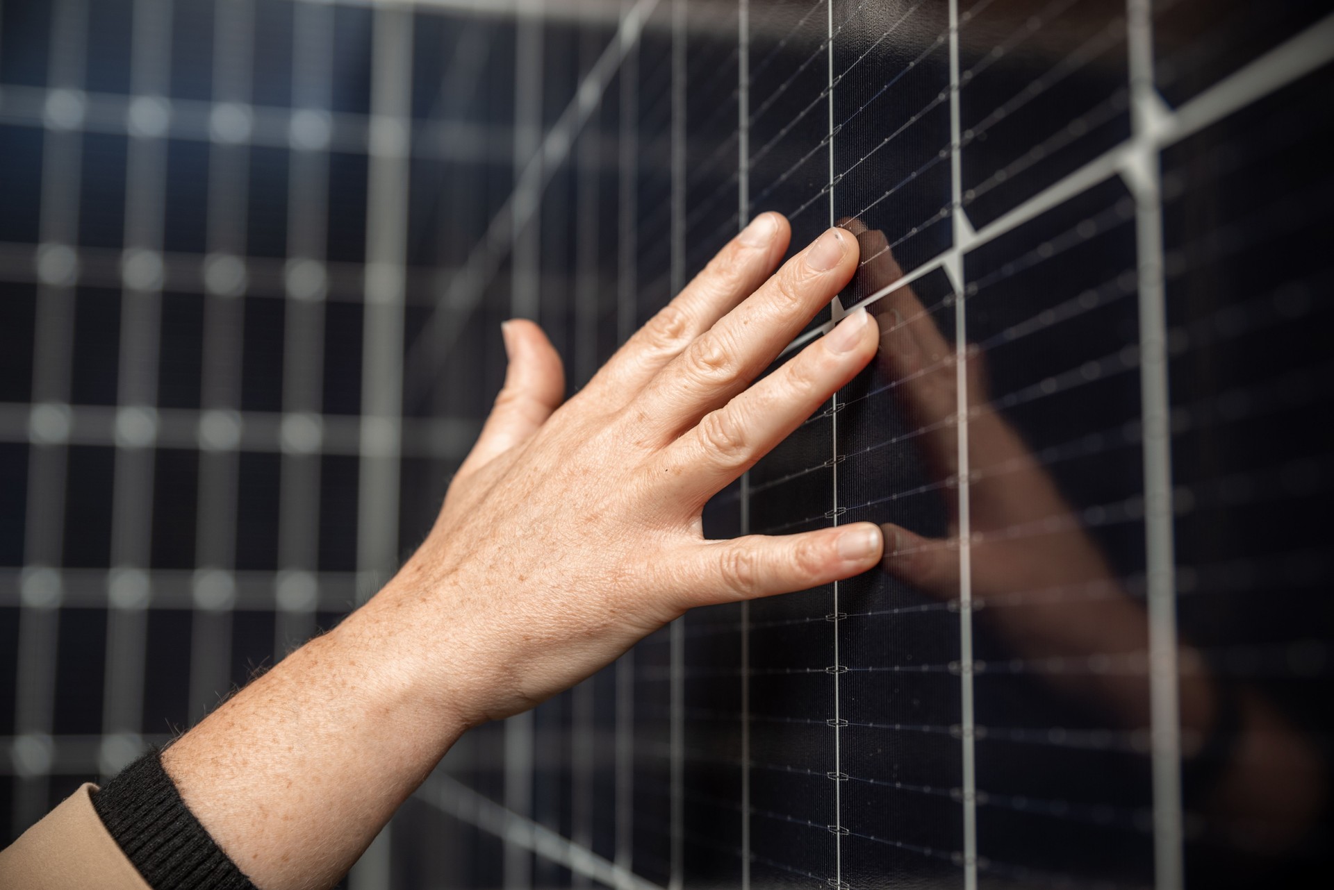 Les mains d’une femme touchent des panneaux d’énergie solaire à la centrale électrique